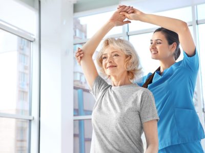 Physiotherapist working with elderly patient in clinic