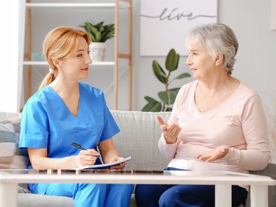Elderly woman suffering from mental disability and caregiver in nursing home